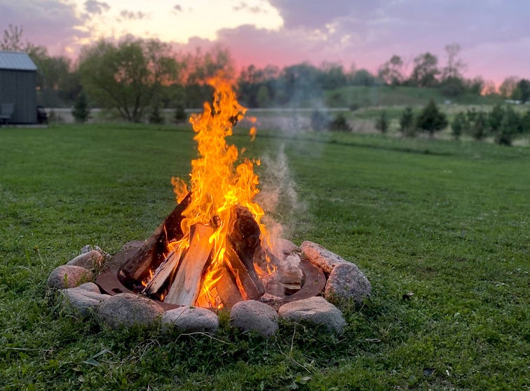 A campfire burning in the early evening. 
