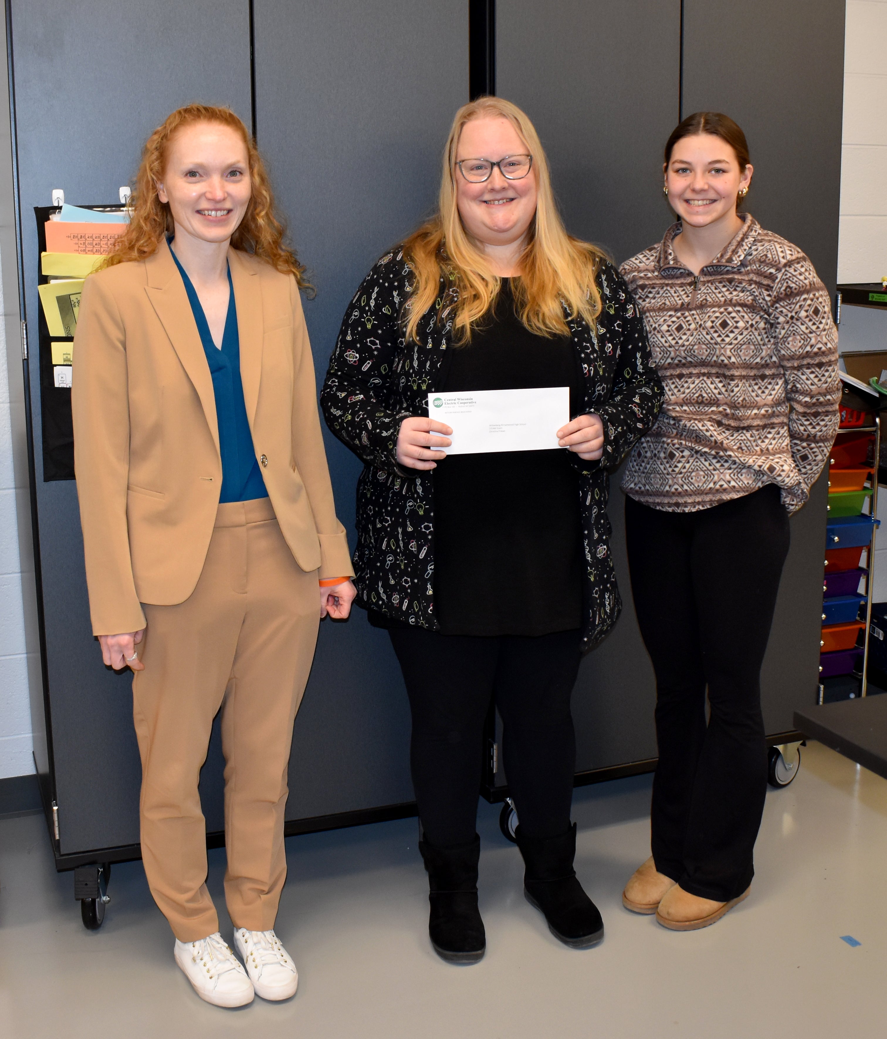 Wittenberg-Birnamwood High School Principal Megan Rothmeyer (left), high school physics and chemistry teacher Christina Priewe (center), and high school junior Reese Dickman (right) accept a $1,000 STEAM grant from Central Wisconsin Electric Cooperative.